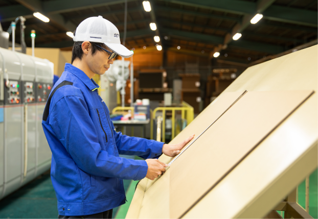 機械から出て来た商品の仕上がりをチェック